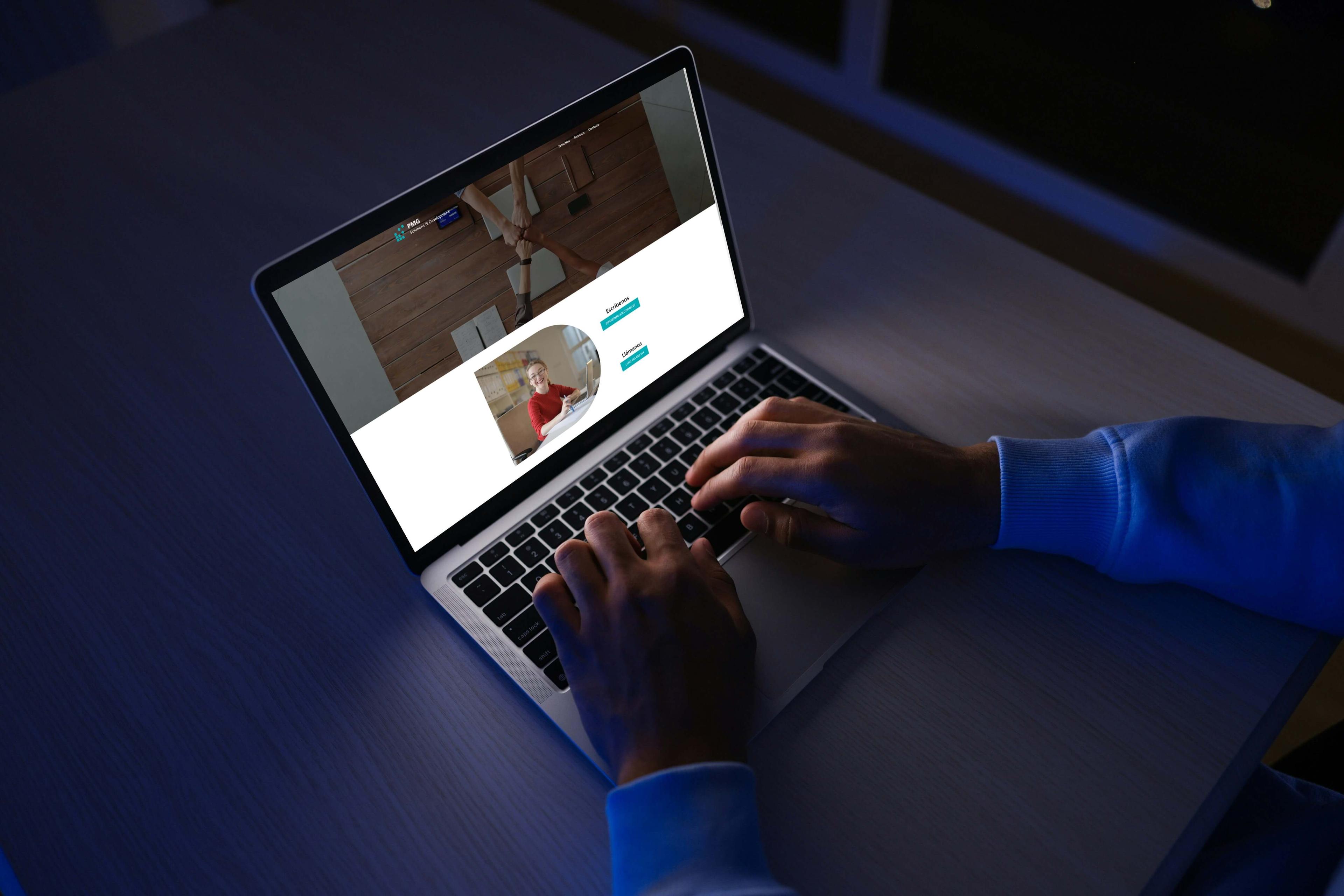 PMG Solutions & Development website displayed on a laptop in a dark workspace